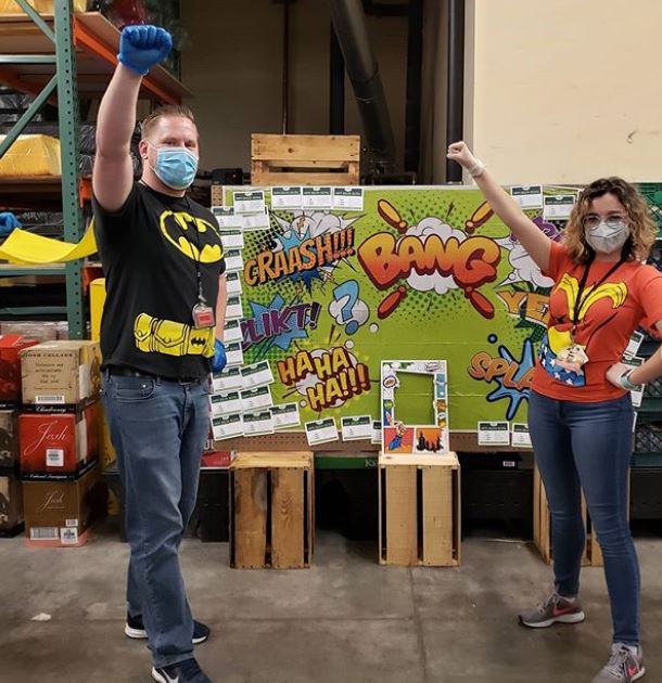 Sprouts team members standing in front of a decorated board of comment cards