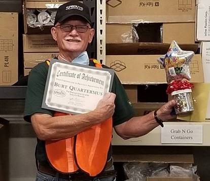 Burt holding an award and certificate