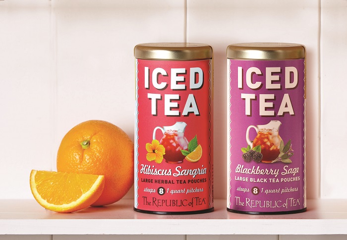 Tins of tea next to an orange
