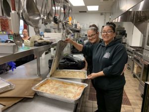 Women in the Saint John's Program for Change culinary training program prepare food in an industrial kitchen.