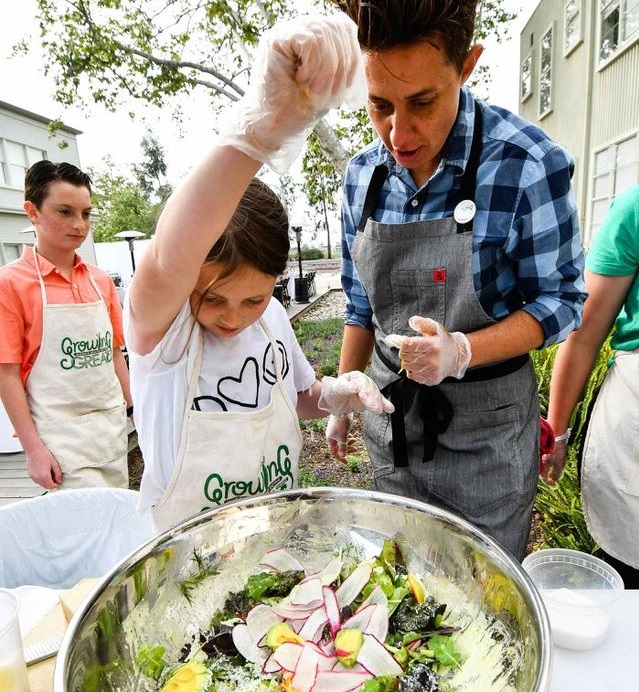 Students make a large salad in their outdoor garden with their teacher.