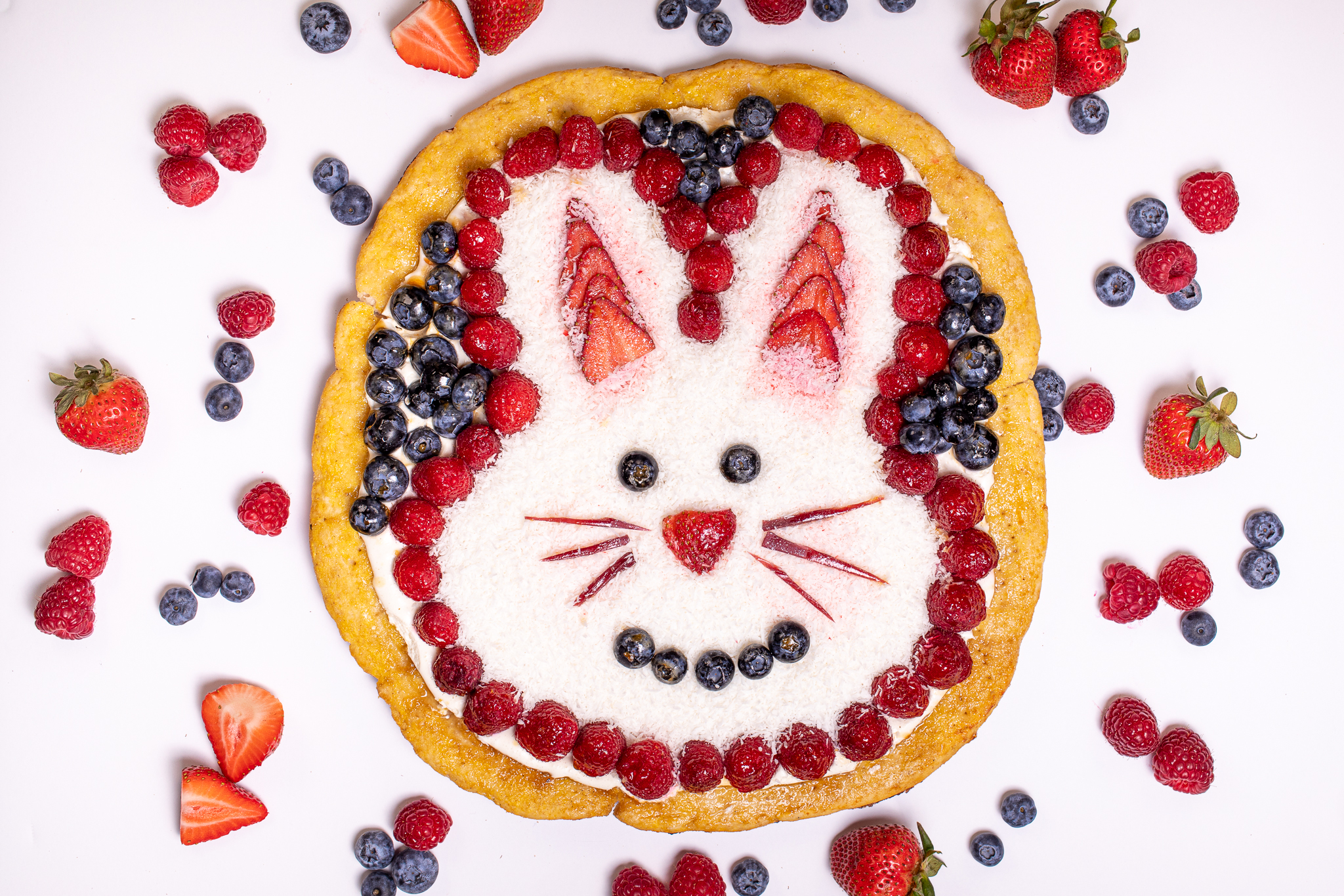 Photo of pizza decorated with fruit and an easter bunny design