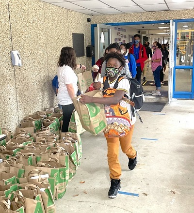 Boy grabs bag of food while leaving school