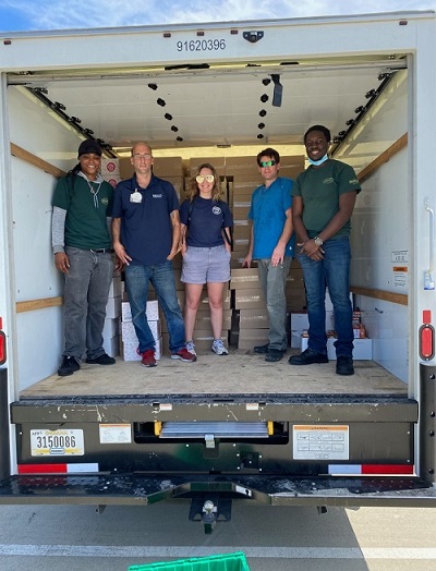 Volunteers smile while loading a truck full of food