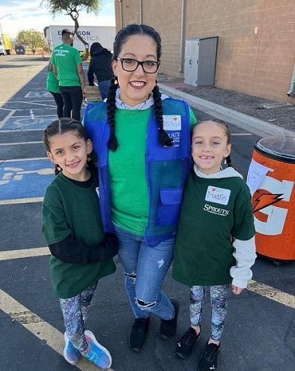 A mom volunteers with her daughters.